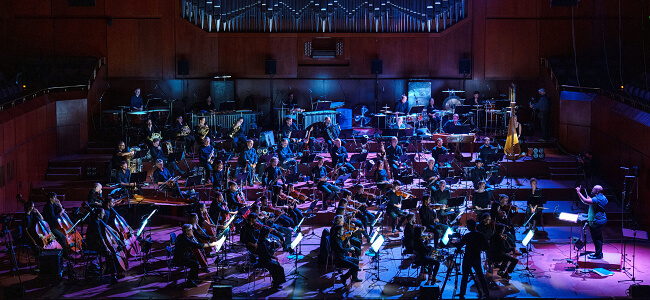 Ein Foto vom Ensemble Modern Orchestra auf einer Konzert-Bühne.